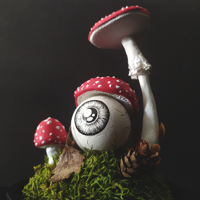 Détail photo sur une sculpture personnalisée d'un œil champignon Amanite tue-mouches sous cloche en verre, par l'artiste Okograph.