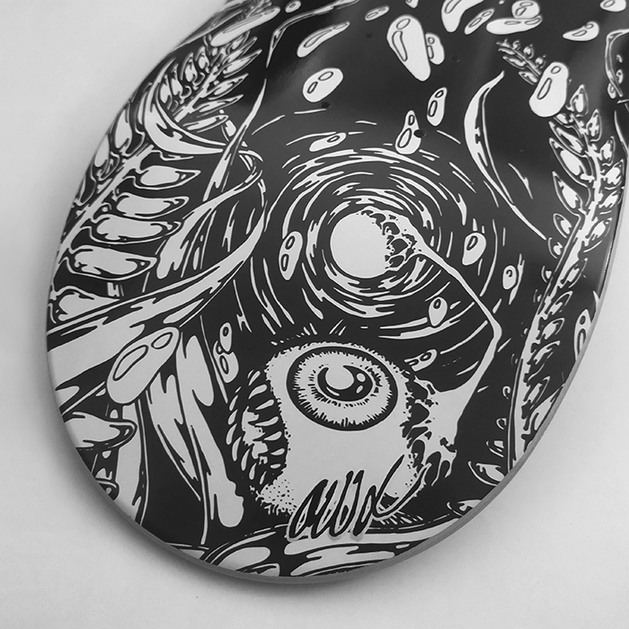 Photo d'un skate illustré par Okograph et édité par SlideBox, l'illustration représente des yeux poisson, méduse et poulpe dans un tourbillon d'eau.
