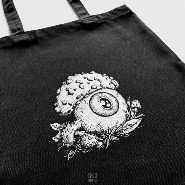 Tote bag artistique illustré avec une création originale de Okograph, c’est un sac de créateur. Le sac est sérigraphié par la main de l'artiste même, il est composé de peinture à base d'eau sur tissu en coton. L’illustration est une œuvre signée Okograph, le motif représente un œil avec chapeau de champignon amanite tue-mouche.